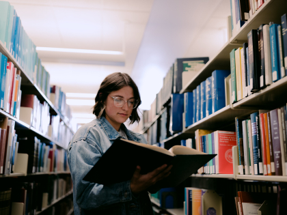 Student between library shelves